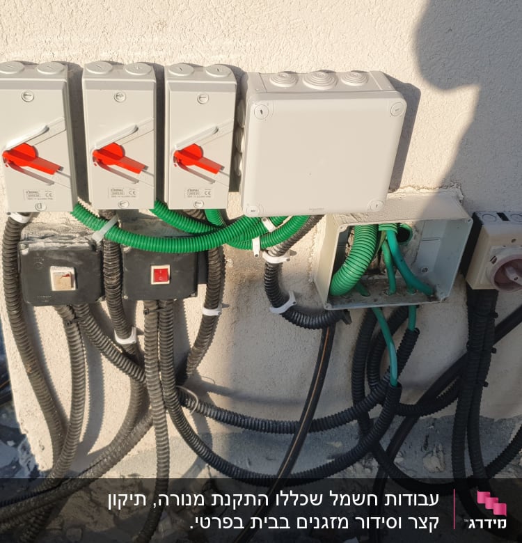 מתגים חשמליים עם כבלים ירוקים ושחורים על קיר